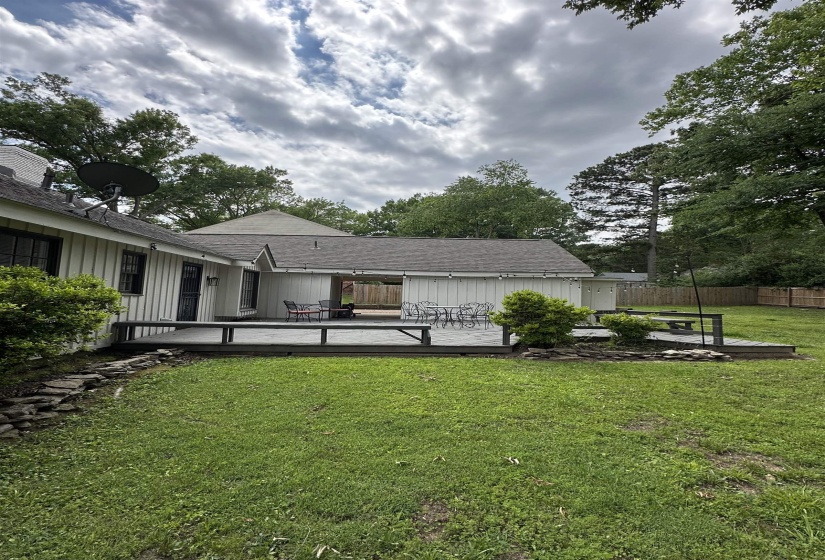 Expansive backyard featuring a multi-level wood deck, a mature lawn, and established perimeter trees