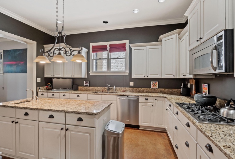 Kitchen with white cabinetry, granite countertops, and stainless steel appliances