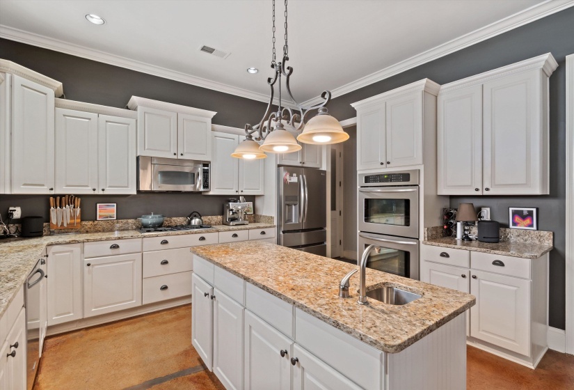 Spacious kitchen featuring white cabinetry, granite countertops, and built-in stainless steel appliances