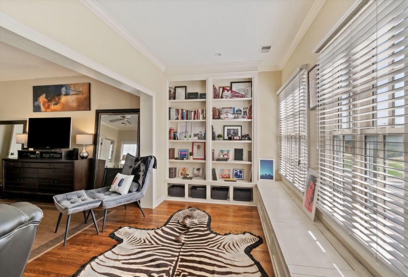 Living space featuring wood-finish flooring and crown molding