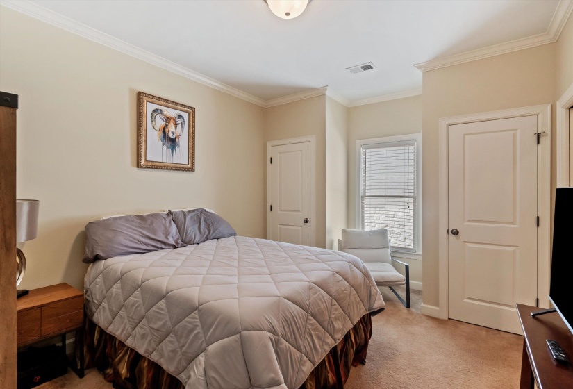 Carpeted room featuring crown molding, neutral wall tones, a ceiling-mounted light fixture, and a window with horizontal blinds