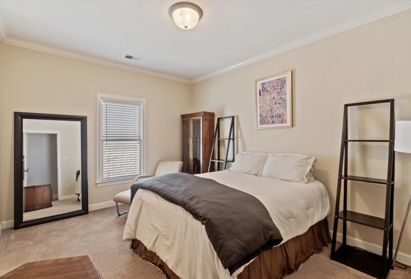 Carpeted room featuring a single window with blinds, crown molding, and a flush-mount ceiling light