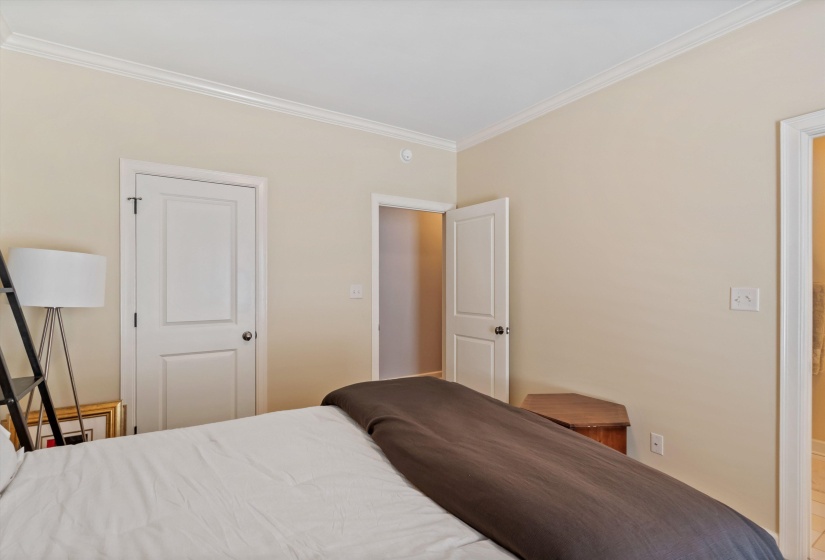 Bedroom featuring neutral paint, crown molding, white trim, and two paneled doors