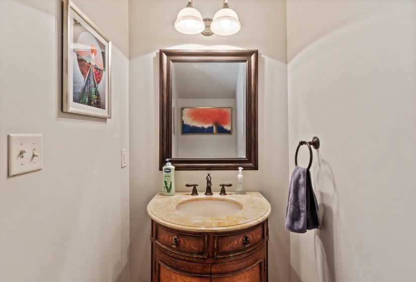 Vanity with a curved wood-finish base, integrated basin, and a light-toned countertop