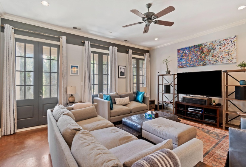 Expansive living area with wood-finish flooring, recessed lighting, and a ceiling fan