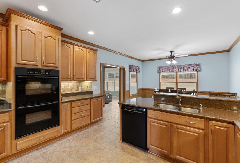 Kitchen featuring light wood cabinetry, stone-finish countertops, and tile flooring