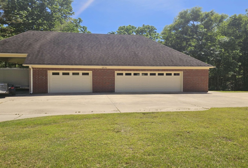 Brick exterior featuring two garage bays with paneled doors and upper window inserts