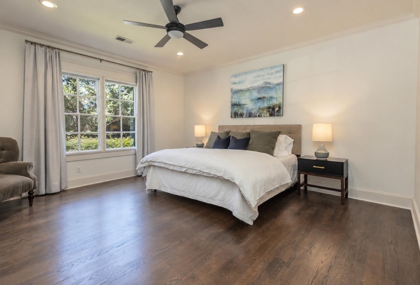 Expansive room featuring dark wood-finish flooring, a contemporary ceiling fan, recessed lighting, crown molding, and large multi-pane windows with garden views