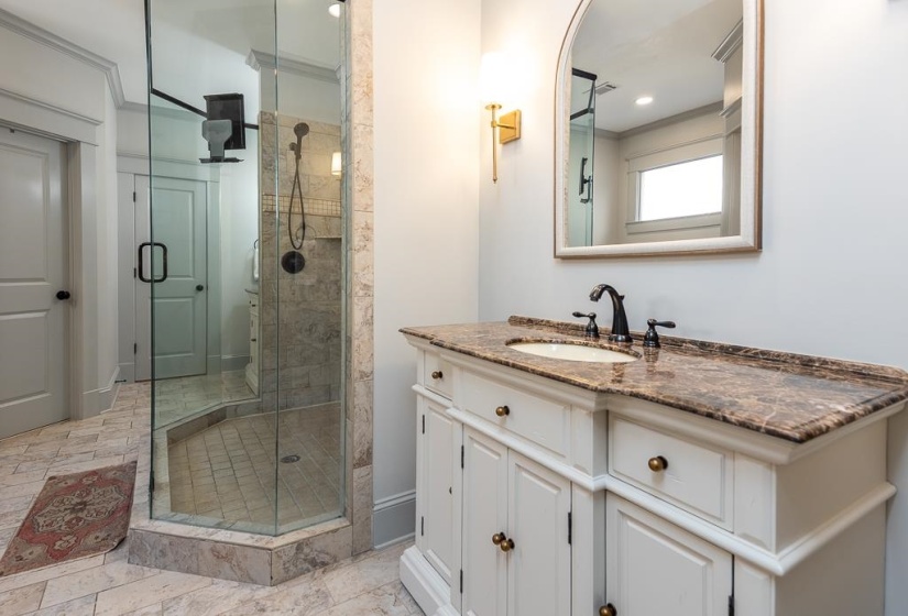 Bathroom featuring a glass-enclosed shower with tiled walls and flooring