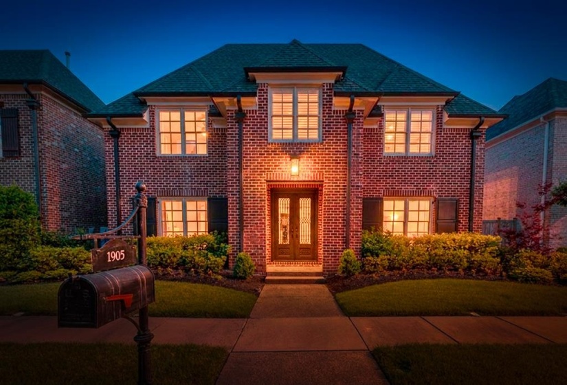 Brick exterior residence featuring a gabled roofline and architectural window details
