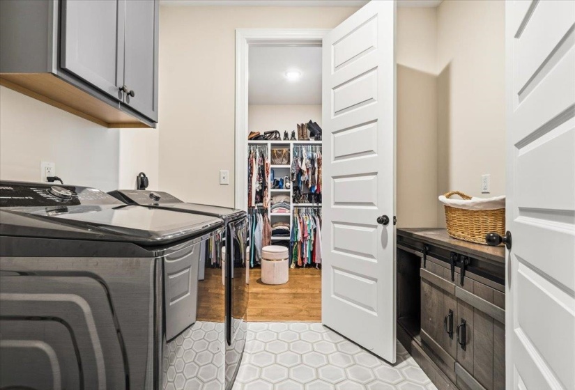Laundry area with cabinet space, light tile patterned flooring, and washer and dryer