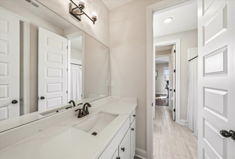 Bathroom featuring a shower with curtain, vanity, light wood finished floors, and a chandelier