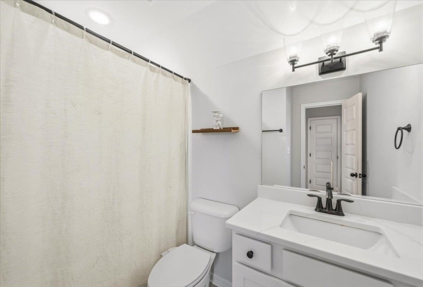 Bathroom with a shower with curtain and vanity