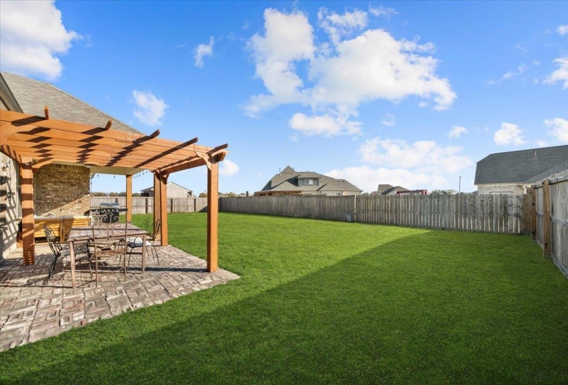 Fenced backyard featuring a pergola, a patio, and a residential view