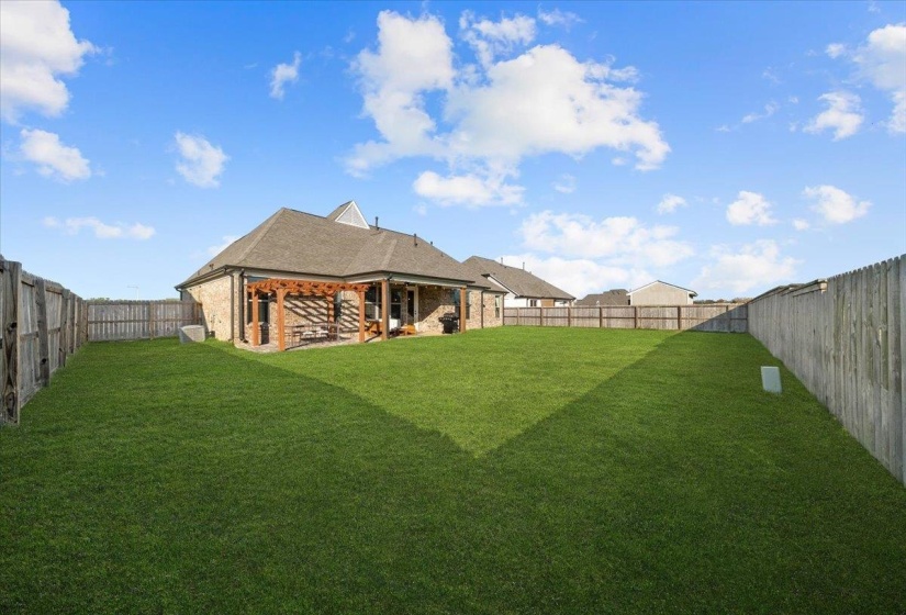 Back of property featuring a fenced backyard, brick siding, a patio area, and a shingled roof