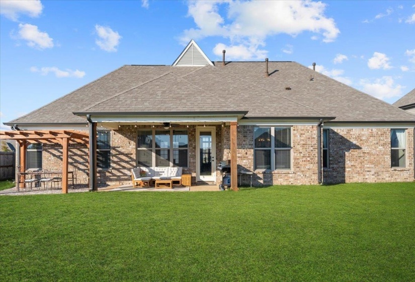 Rear view of property with a patio area, roof with shingles, brick siding, and a ceiling fan