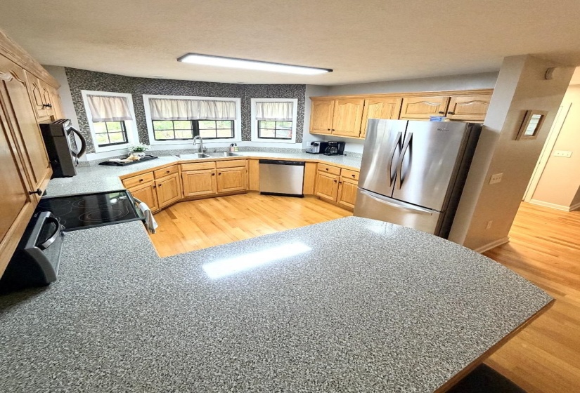Open-concept kitchen featuring U-shaped cabinetry with a built-in double basin sink and a dedicated cooking area
