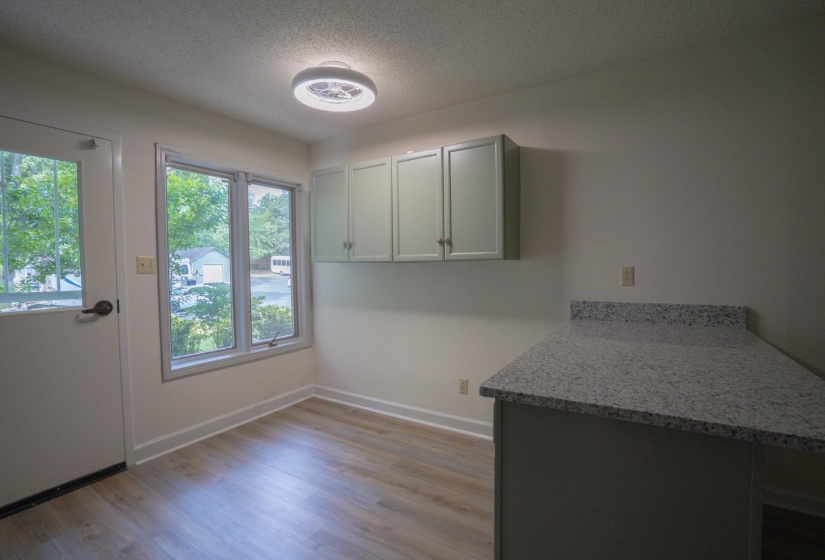 Bright interior space featuring wood-finish flooring, white walls, and a recessed ceiling light
