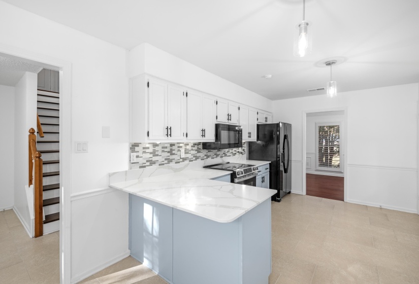 Kitchen featuring white cabinetry, modern black hardware, and a mosaic tile backsplash
