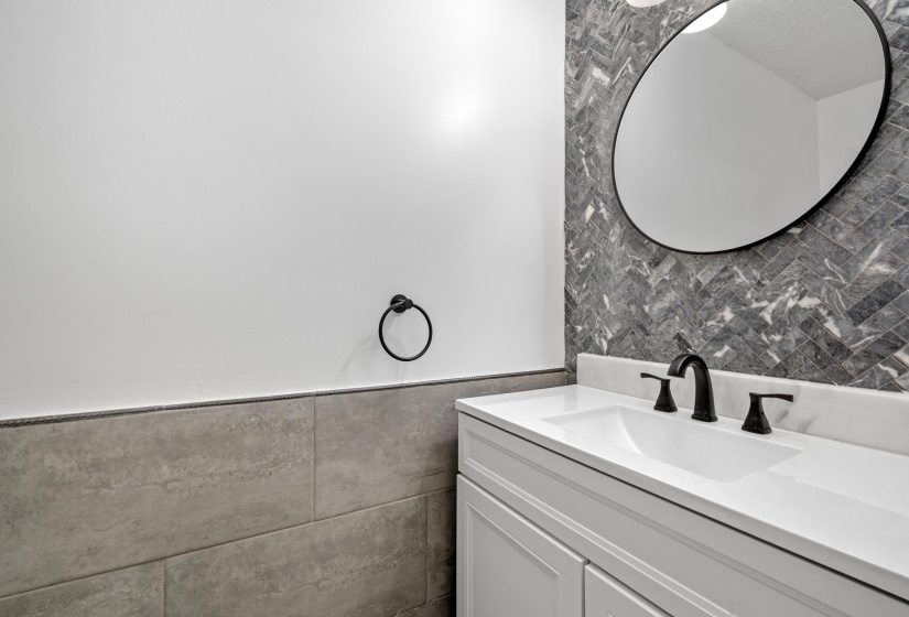 Modern vanity with integrated sink, matte black faucet, and white countertop