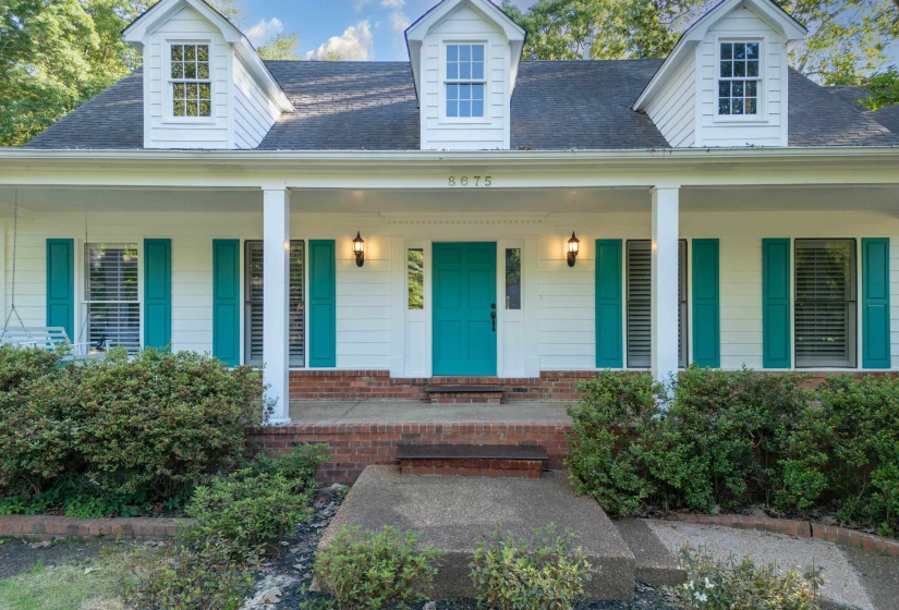 White exterior with teal shutters and a matching teal entry door
