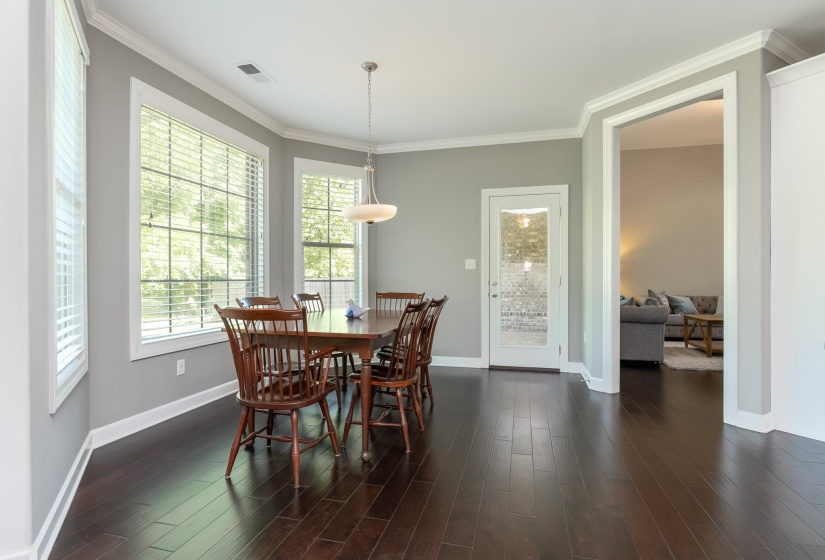 Dining area featuring wood-finish flooring and a contemporary chandelier