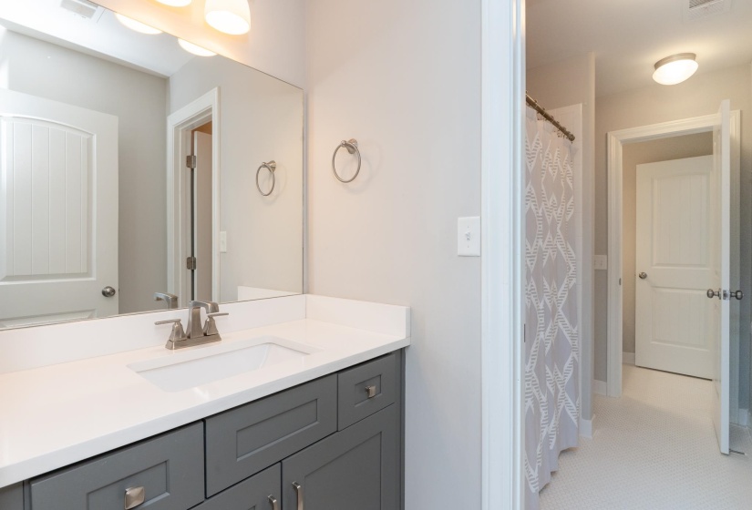 Bathroom featuring a gray vanity with an integrated white sink and brushed nickel faucet