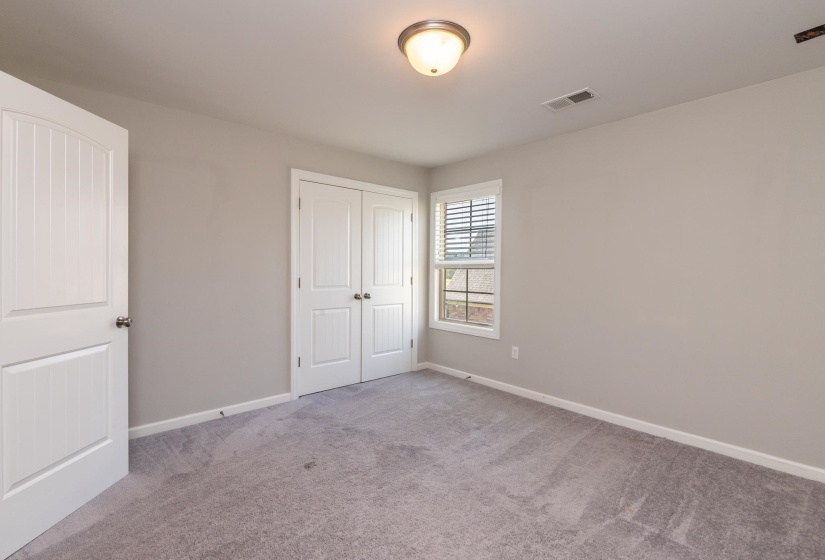 Interior room featuring light gray wall paint, gray carpet flooring, and white trim
