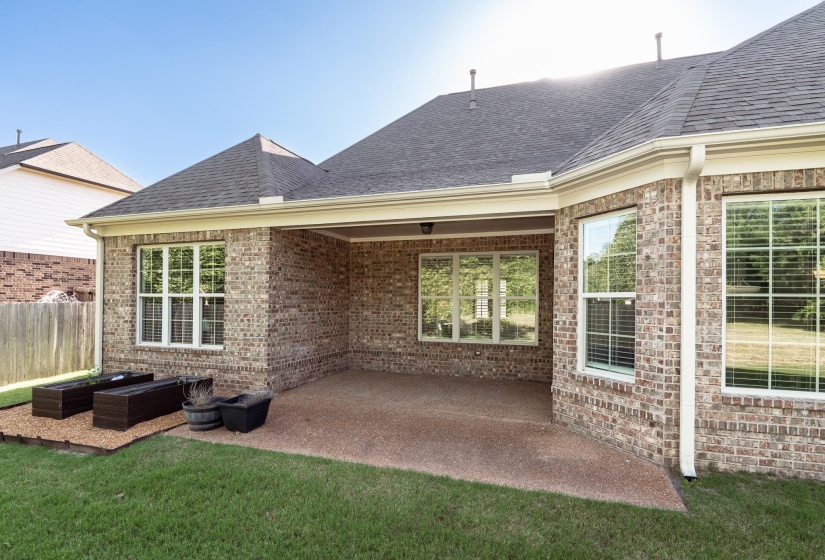 Brick exterior featuring a covered patio and multiple windows