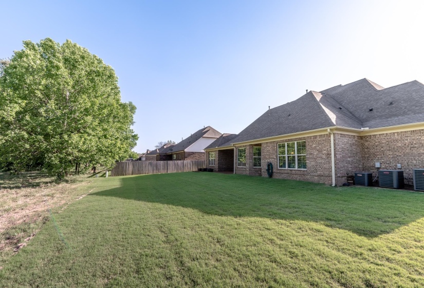 Expansive grass lawn with a full-brick exterior and multiple windows