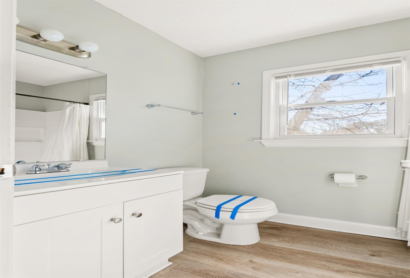 Full bath featuring vanity, light wood-type flooring, and curtained shower