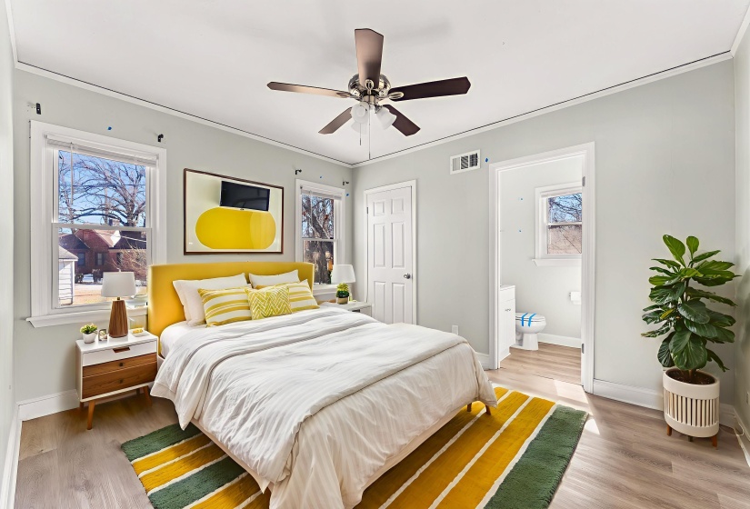 Bedroom with light wood finished floors, connected bathroom, a ceiling fan, and crown molding