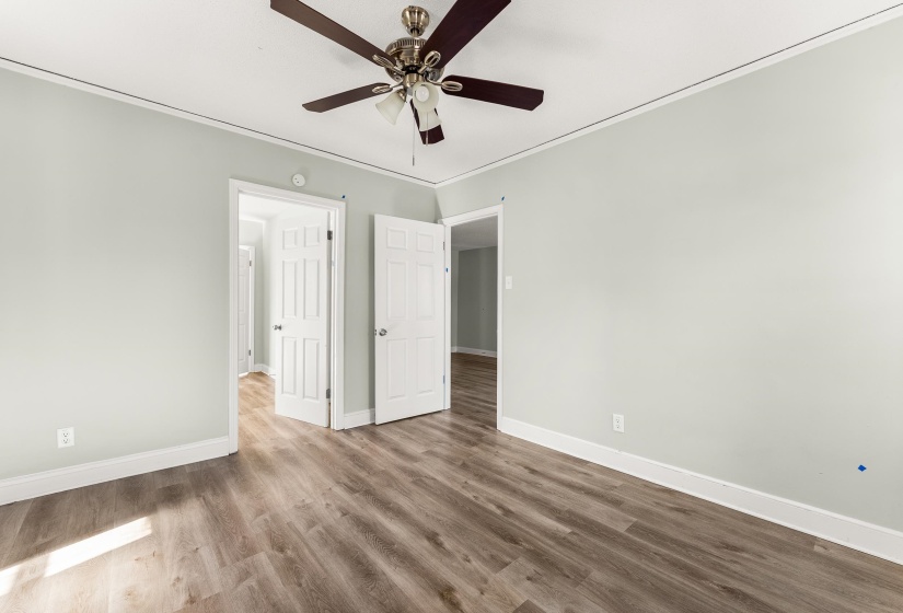 Unfurnished bedroom featuring ceiling fan, wood finished floors, and crown molding