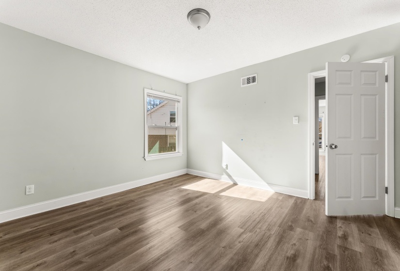 Spare room with wood finished floors and a textured ceiling