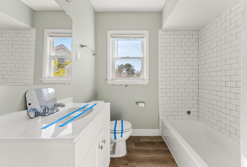 Bathroom with vanity, dark wood-type flooring, and  shower combination