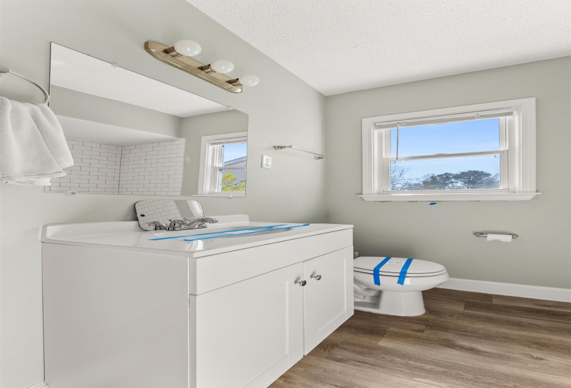 Half bath featuring vanity, dark wood finished floors, and a textured ceiling