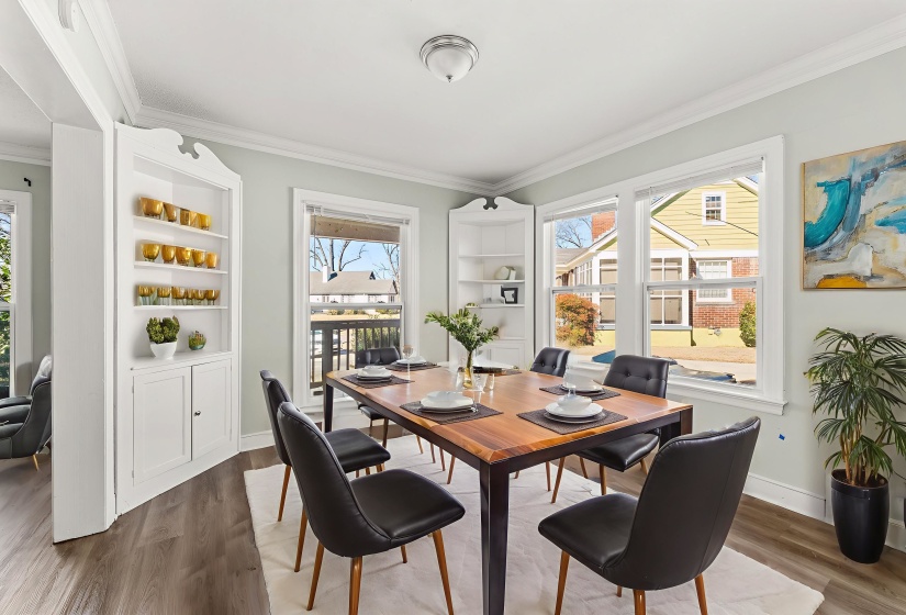 Dining area with plenty of natural light, ornamental molding, built in shelves, and dark wood-style flooring