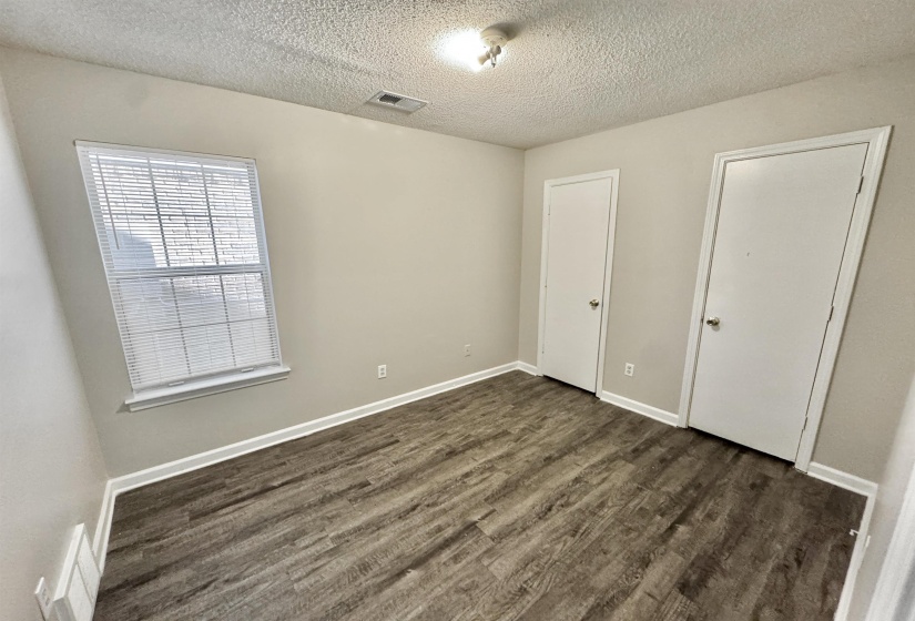 Room featuring wood-finish flooring, neutral wall paint, and white trim