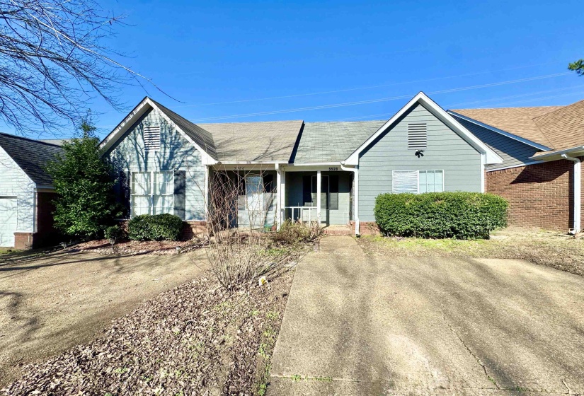 Single-story residence featuring light blue siding, a covered entry porch, and a concrete driveway