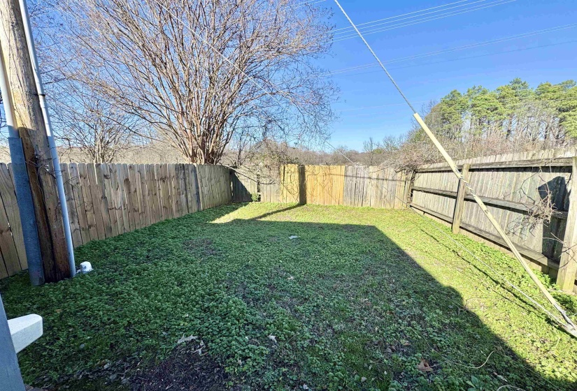 Fully fenced backyard featuring a grassy area