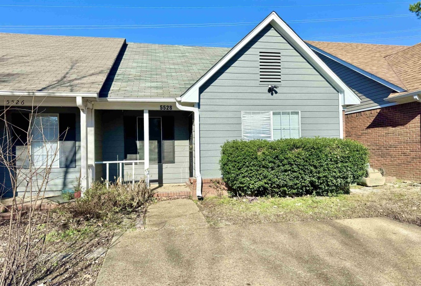 Shingle roof with a prominent gable, light blue siding, and brick accents