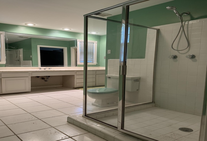 Full bathroom featuring a glass-enclosed shower with white tile surround, a dual vanity with ample counter space, and integrated overhead lighting