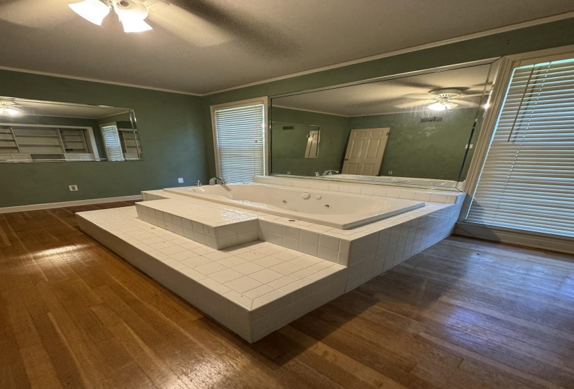 Jetted soaking tub set within a tiled platform with integrated steps