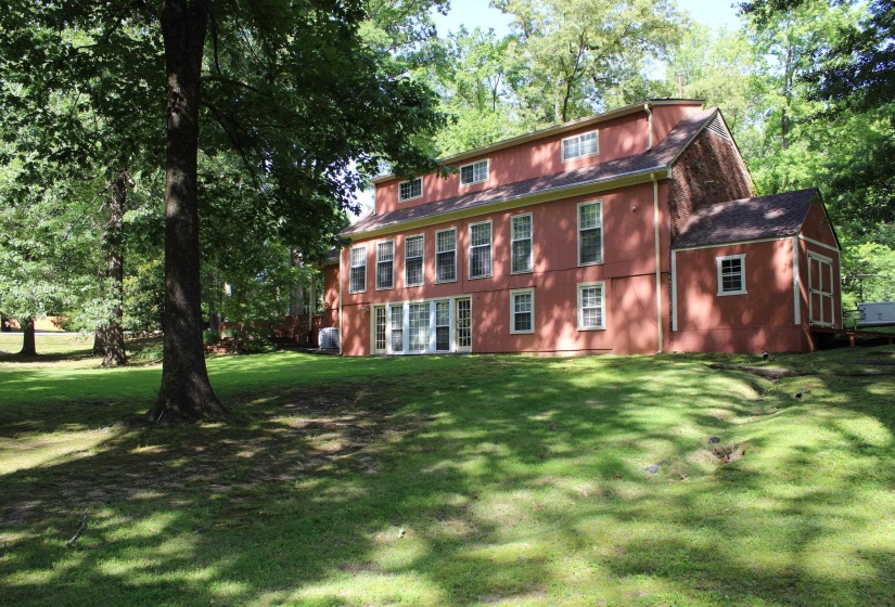 Expansive lawn area with mature trees providing shade