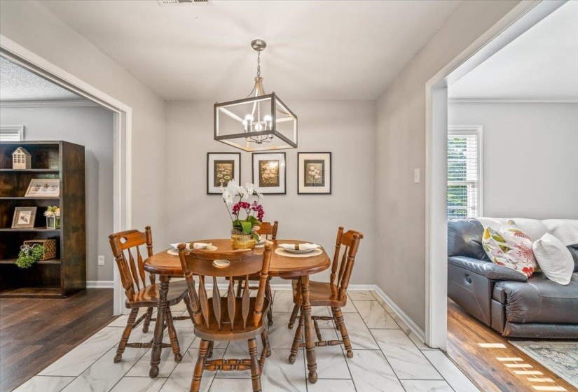 Dining area featuring white tile flooring and a contemporary chandelier