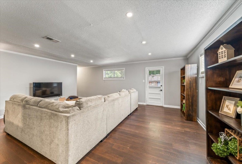 Spacious room featuring wood-finish flooring, recessed lighting, and light gray wall paint