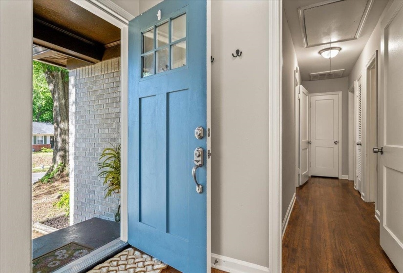 Entryway featuring a blue paneled door with glass inserts, brushed nickel hardware, and wood-finish flooring