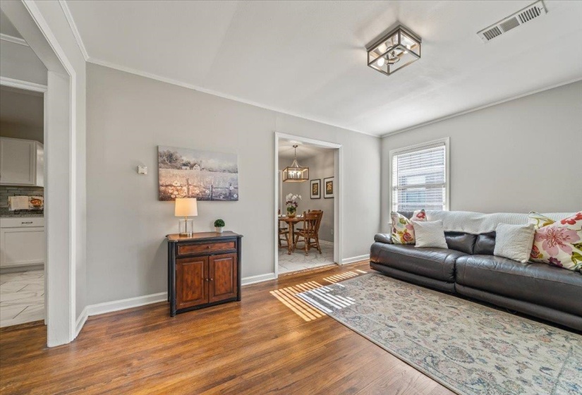 Open living area featuring wood-finish flooring, light gray wall tones, and white trim