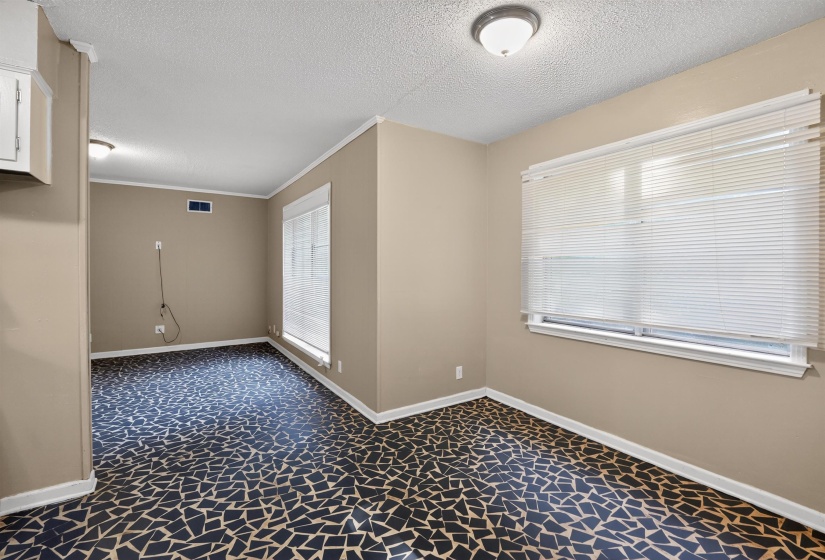 Room featuring patterned tile flooring, light beige walls, and white trim