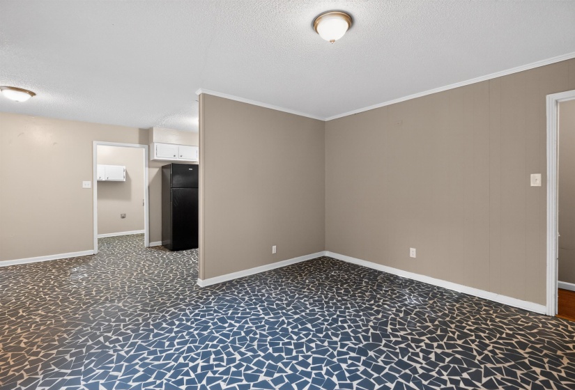 Interior space featuring patterned blue and white flooring, neutral wall paint, and white trim